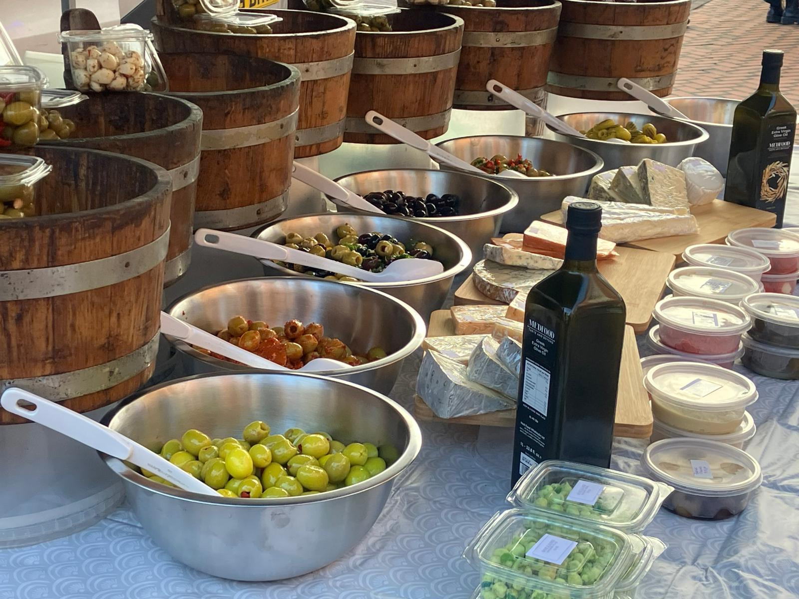 Close-up of mixed olives, cheeses, oils and herbs on display