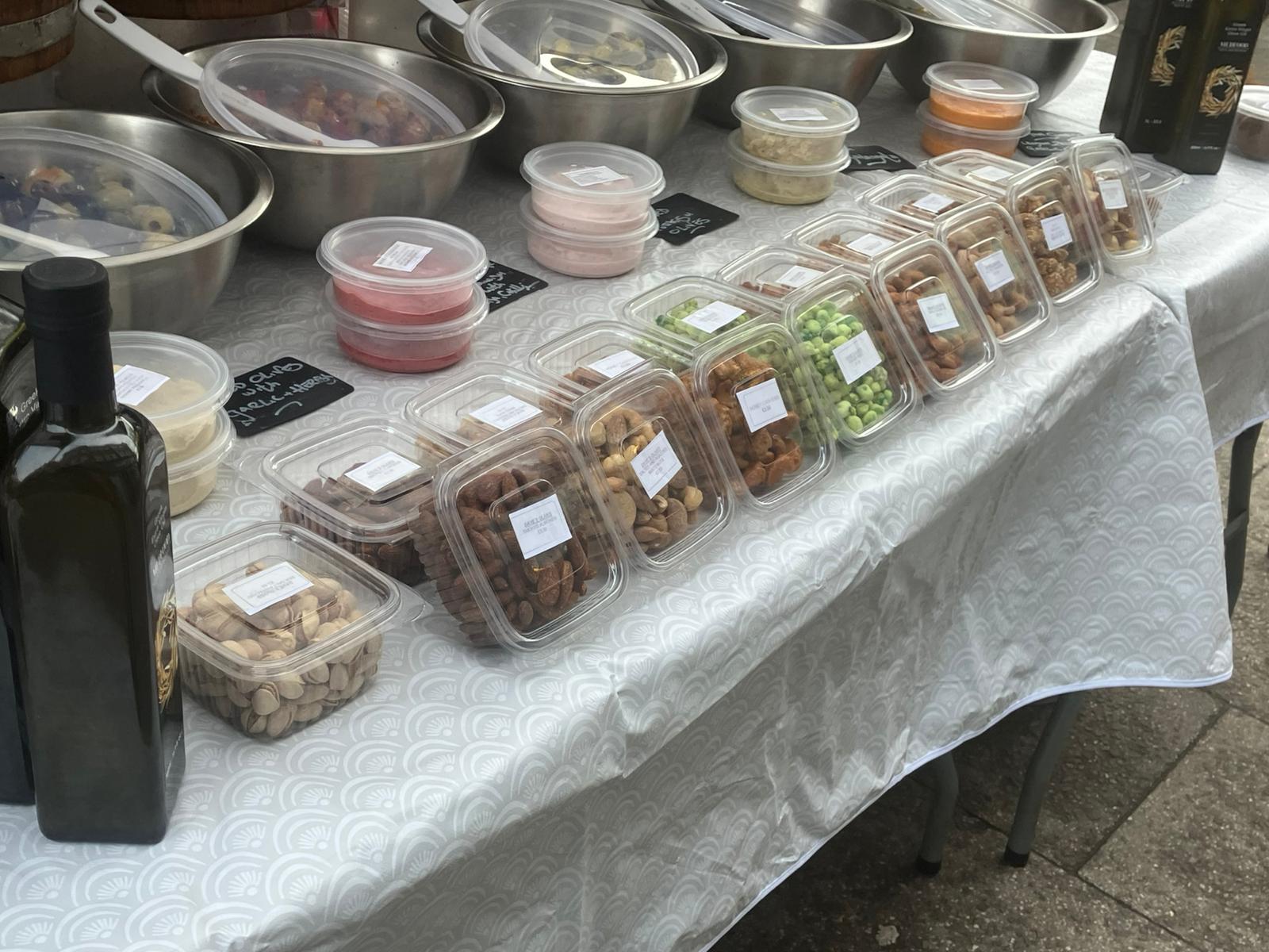 Packaged nuts, dips and prepared olive products on market table