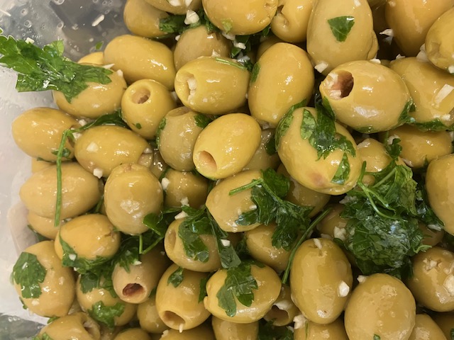 Fresh green pitted olives marinated in lemon juice, parsley and garlic